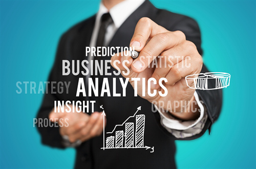 Business man writing on a clear wall with charts and the words prediction, business, analytics, strategy, statistics, insight, process, graphics on it.