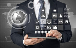 Person in a business suit holding a tablet with floating digital icons above it, including a globe, gears, charts, and people symbols, alongside a vertical list of business terms such as innovation, solution, branding, ideas, marketing, success, management, and analysis.